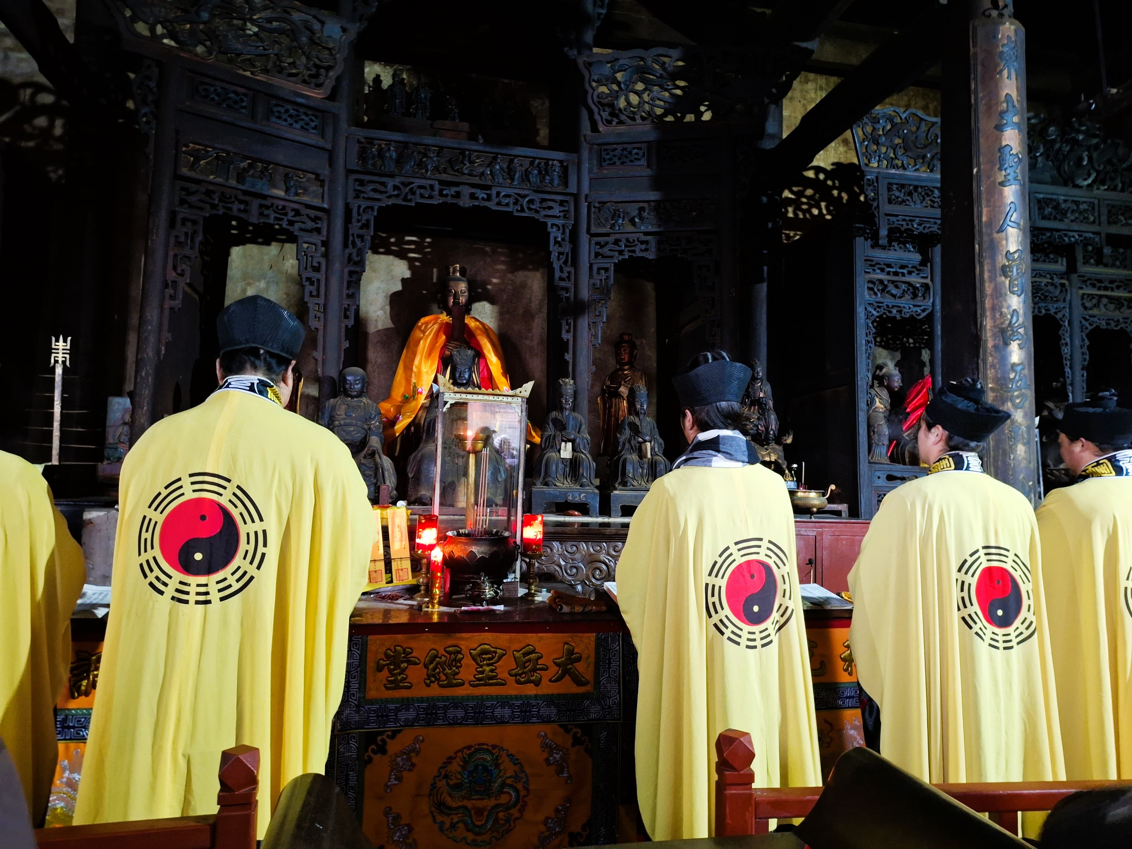 Temple interior at Wudang Mountain with visitors and attendants.